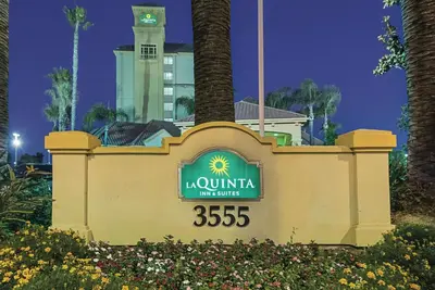 a sign for a hotel in front of a building at La Quinta Inn & Suites by Wyndham Ontario Airport in Ontario