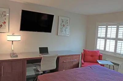 a bedroom with a desk with a laptop and a bed at Del Mar Motel in Rosemead