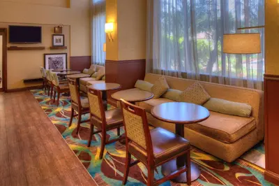 a waiting room with tables and a couch and chairs at Hampton Inn & Suites Ontario in Ontario