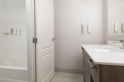 a white bathroom with a shower and a sink at Homewood Suites by Hilton Ontario Rancho Cucamonga in Rancho Cucamonga