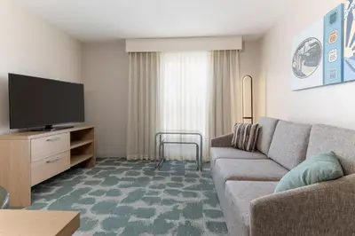 a living room with a couch and a flat screen tv at Homewood Suites by Hilton Ontario Rancho Cucamonga in Rancho Cucamonga