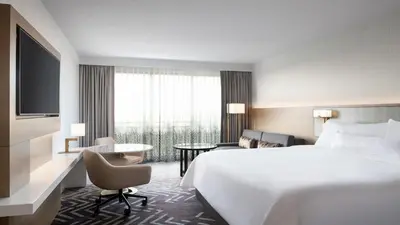a hotel room with a large bed and a desk at The Westin Anaheim Resort in Anaheim