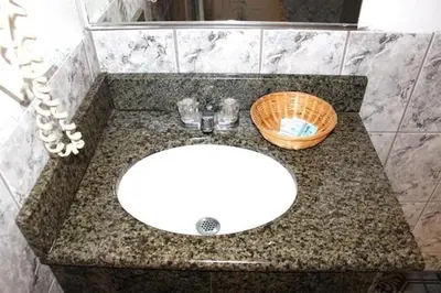 a bathroom counter with a sink and a basket on it at Beacon Motel in Long Beach