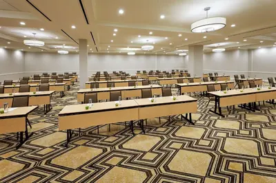 an empty lecture hall with tables and chairs at Hilton Pasadena in Pasadena