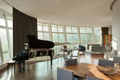 a living room with a piano and a living room with a couch at Loews Hollywood Hotel in Los Angeles
