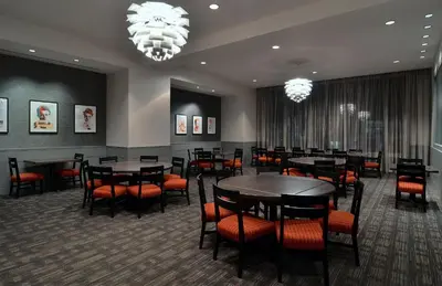 a dining room with tables and chairs and chandeliers at Loews Hollywood Hotel in Los Angeles