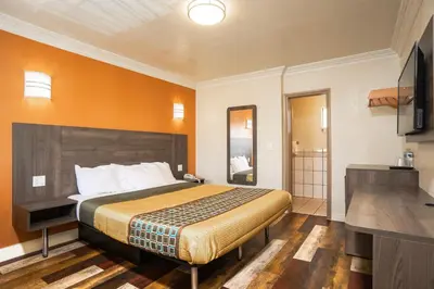 a hotel room with a bed and a television at Economy Inn Hollywood in Los Angeles