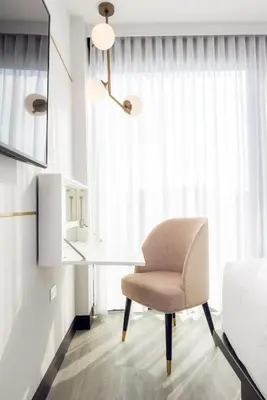 a bedroom with a desk and a chair in front of a window at The Godfrey Hotel Hollywood in Los Angeles