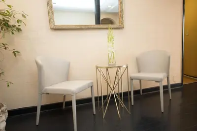 two white chairs and a table with a mirror at Wilshire Crest Hotel in Los Angeles