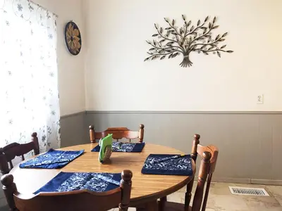 a dining room table with chairs and a clock on the wall at Cozy Suite near City of hope in Duarte