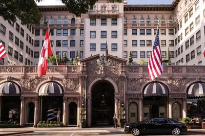a car parked in front of a building with flags at Beverly Wilshire, Beverly Hills, A Four Seasons Hotel in Los Angeles