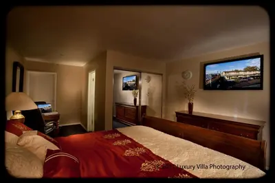 a bedroom with a bed and a flat screen tv at Crystal Lodge Motel in Ventura