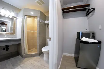 a bathroom with a toilet and a sink and a shower at Crystal Lodge Motel in Ventura