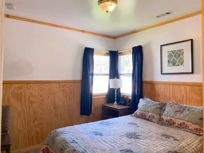 a bedroom with a bed with blue curtains and a window at Blue Horizon Lodge in Big Bear Lake