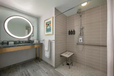 a bathroom with a shower and a sink and a mirror at Hotel Dena, Pasadena Los Angeles, a Tribute Portfolio Hotel in Pasadena