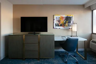a room with a desk with a television and a chair at Hotel Dena, Pasadena Los Angeles, a Tribute Portfolio Hotel in Pasadena