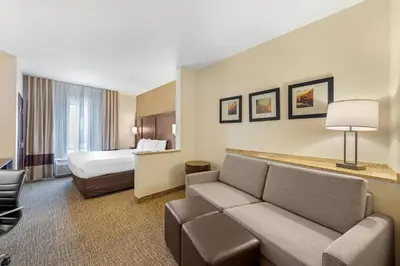 a hotel room with a couch and a bed at Comfort Suites Ontario Airport Convention Center in Ontario