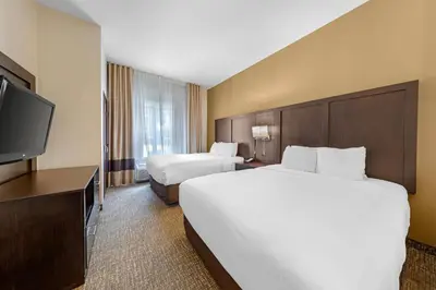 a hotel room with two beds and a flat screen tv at Comfort Suites Ontario Airport Convention Center in Ontario