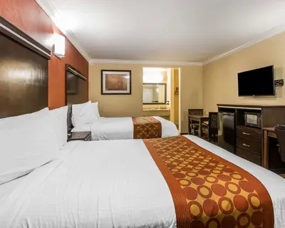 a hotel room with two beds and a flat screen tv at Rodeway Inn & Suites Corona in Corona