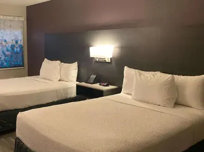 a hotel room with two beds with white pillows at La Quinta Inn by Wyndham Bakersfield South in Bakersfield