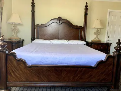 a large wooden bed in a bedroom with two lamps at Viking Motel-Ventura in Ventura