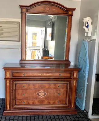 a wooden dresser with a mirror on top of it at Viking Motel-Ventura in Ventura