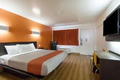 a hotel room with a bed and a flat screen tv at Motel 6-Claremont, CA in Claremont