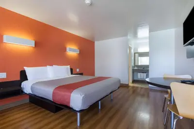 a hotel room with a bed and a table at Motel 6-Claremont, CA in Claremont