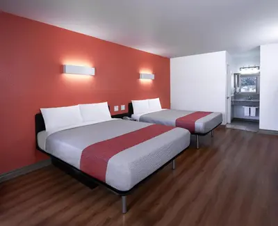 two beds in a room with red walls at Motel 6-Claremont, CA in Claremont