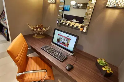 a desk with a laptop computer on top of it at Eden Roc Inn & Suites near the Maingate in Anaheim