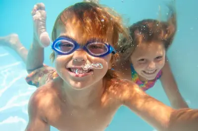 two young children in the water in a swimming pool at Eden Roc Inn & Suites near the Maingate in Anaheim