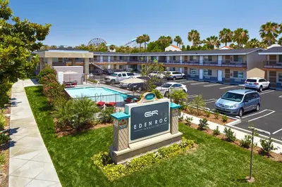 a sign in front of a parking lot with a hotel at Eden Roc Inn & Suites near the Maingate in Anaheim