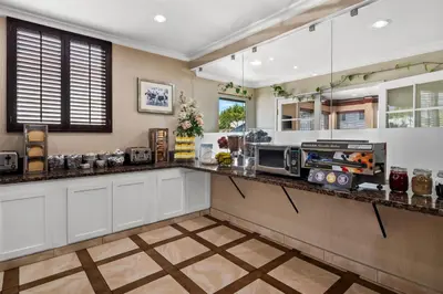 a kitchen with white cabinets and a counter top at SureStay Hotel by Best Western Santa Monica in Los Angeles