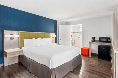 a bedroom with a large bed with a blue wall at SureStay Hotel by Best Western Santa Monica in Los Angeles