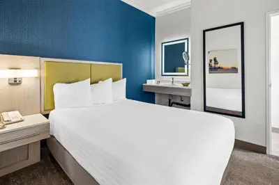 a hotel room with a large bed and a mirror at SureStay Hotel by Best Western Santa Monica in Los Angeles