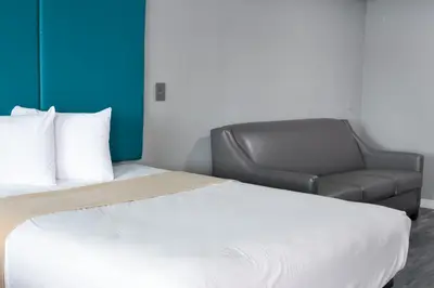 a bed and a chair in a room at Tilbury Inn in Glendale