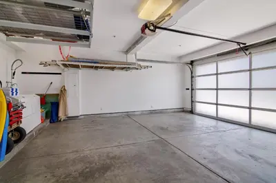 a garage with white walls and a concrete floor at The Swaying Palm Haaven in Seal Beach