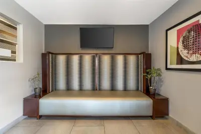 a room with a couch and a tv on a wall at Best Western Plus Pavilions in Anaheim
