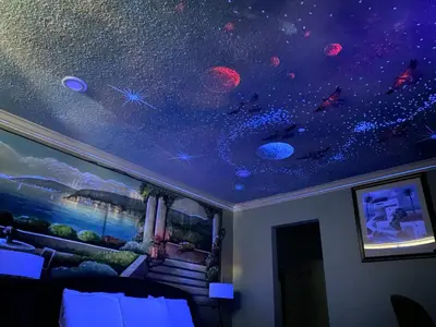 a bedroom with a mural of planets and stars on the ceiling at Villa Park Motel in Orange