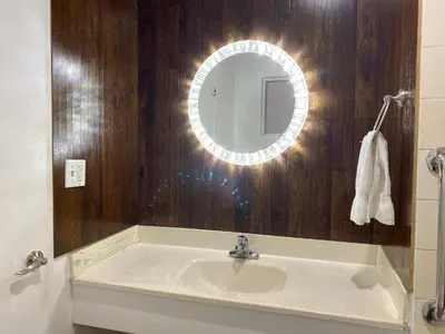 a bathroom with a sink and a mirror at Villa Park Motel in Orange