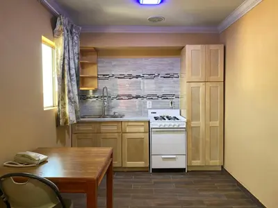 a kitchen with a table and a stove top oven at Villa Park Motel in Orange
