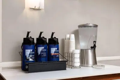 a shelf with three bottles of water and a blender at La Quinta by Wyndham Bakersfield North in Bakersfield