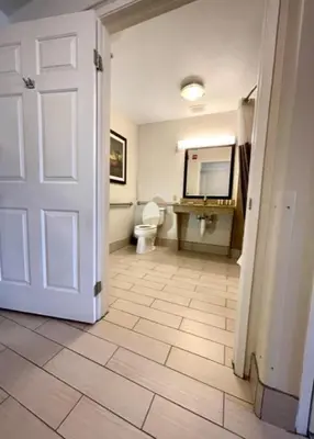 a bathroom with a toilet and a white door at La Quinta by Wyndham Bakersfield North in Bakersfield