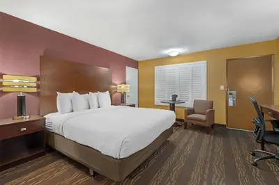 a hotel room with a large bed and a desk at Best Western Plus Stovall's Inn in Anaheim