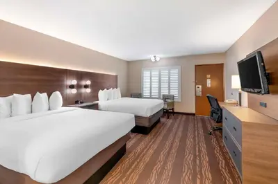 a hotel room with two beds and a flat screen tv at Best Western Plus Stovall's Inn in Anaheim