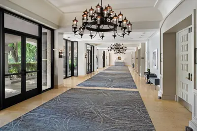 a hallway with a blue rug and a chandelier at Hyatt Regency Westlake in Westlake Village