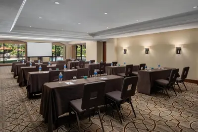 a conference room with tables and chairs and a screen at Hyatt Regency Westlake in Westlake Village