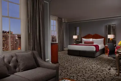 a hotel room with a bed and a couch at The Biltmore Los Angeles in Los Angeles