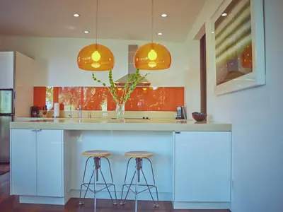 a kitchen with two stools at a counter with two lights at Palms Place in Los Angeles
