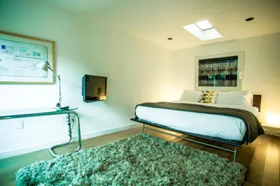 a bedroom with a bed and a television and a rug at Venice Place in Los Angeles